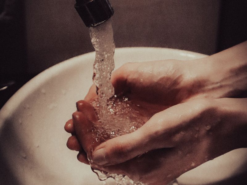 hands running under cold water from a faucet