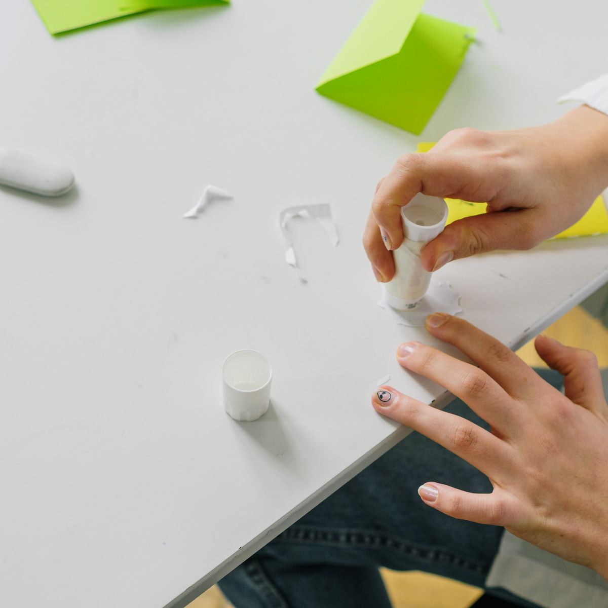 hand applying glue stick to a surface product photo