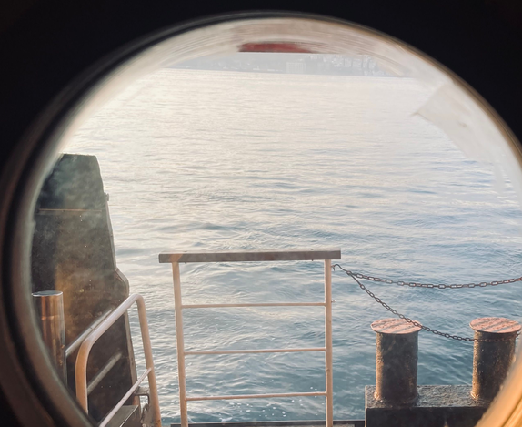 View through a ship porthole window to the ocean hero image
