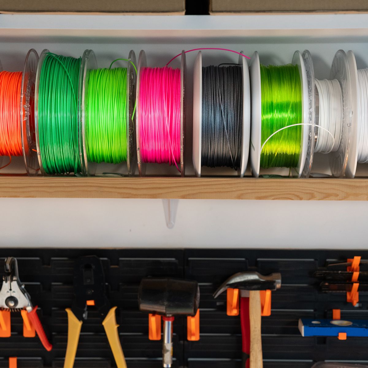 colorful filament spools organized on a wall mounted rack product photo
