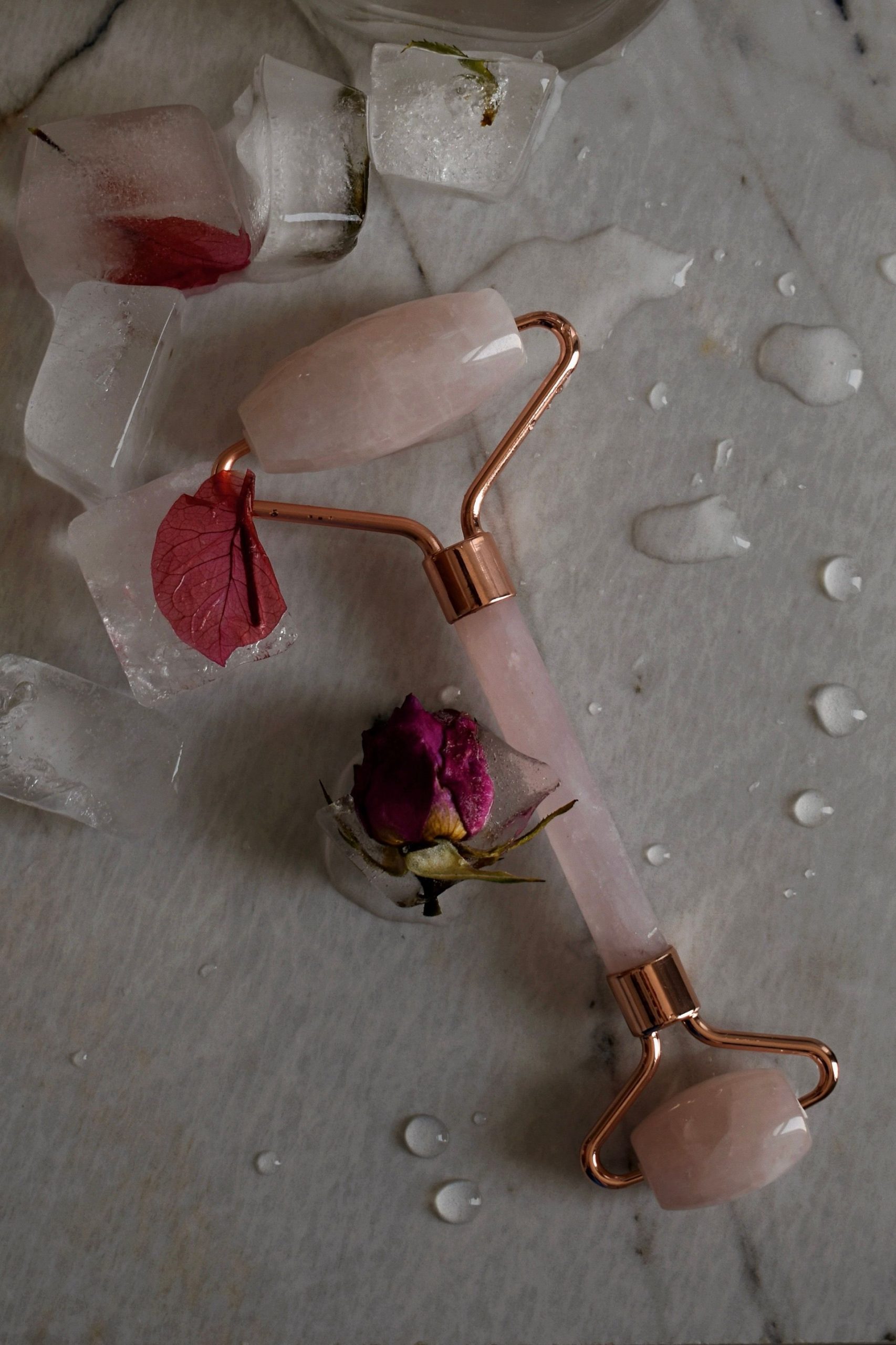 Rose quartz facial roller chilling on ice cubes