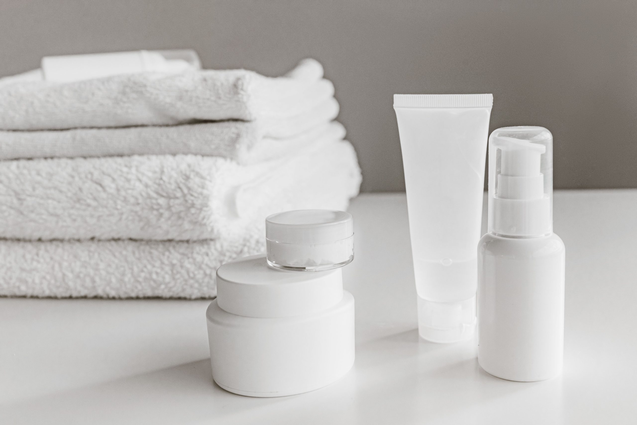 White skincare bottles and jars representing a cooling eye cream routine