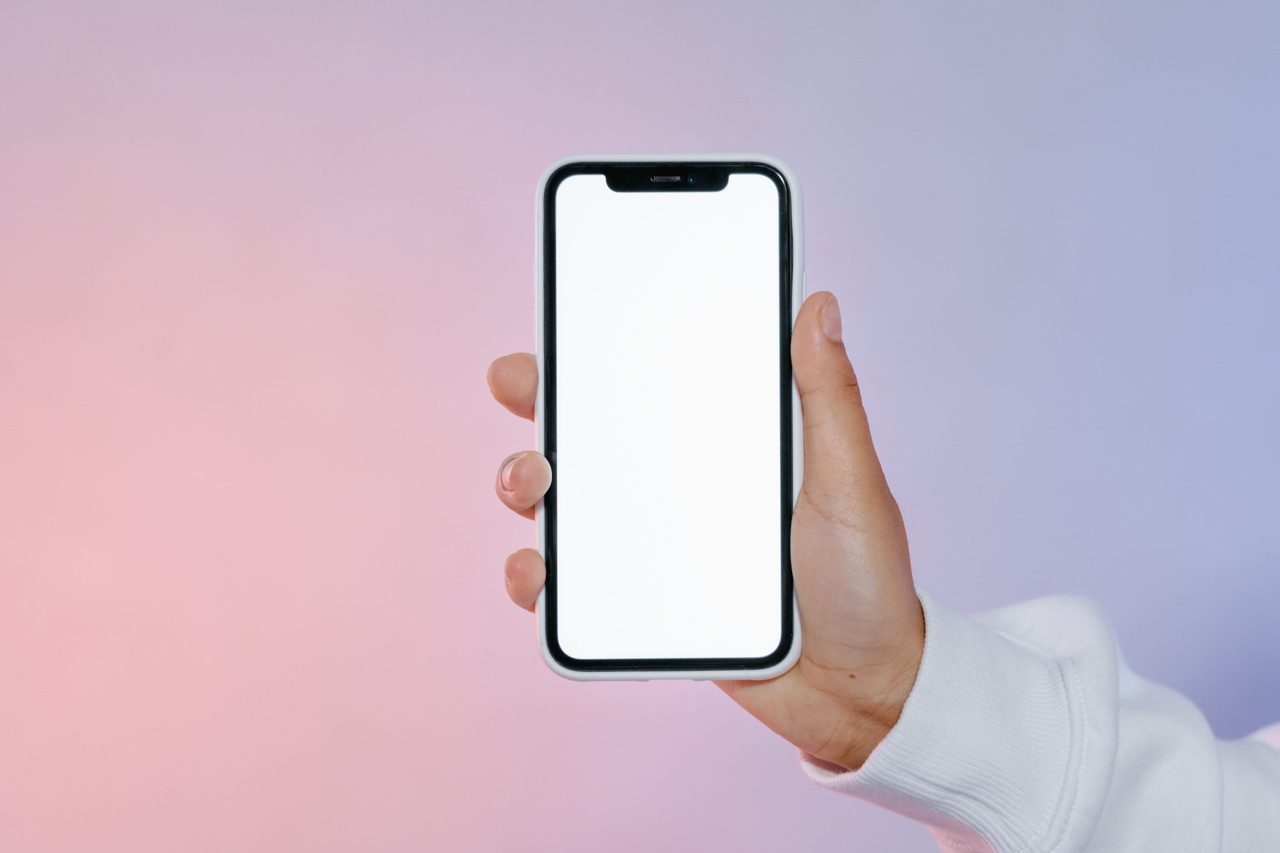 Hand holding a phone with a blank home screen, representing a decluttered, distraction-free phone layout