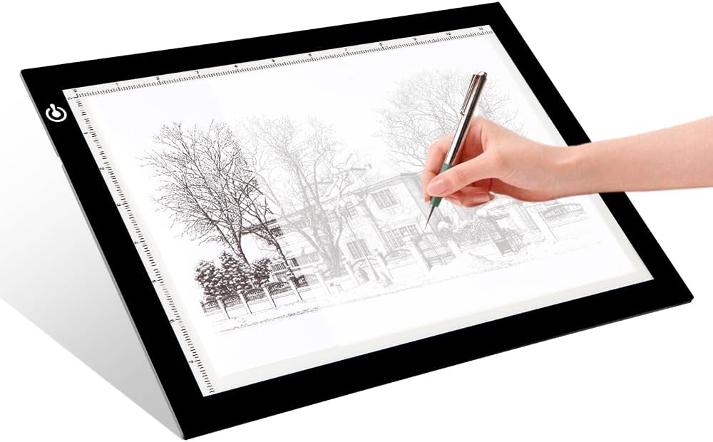 LED light pad used for tracing artwork with a hand holding a pen