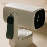 a modern white portable mini projector with a carrying strap