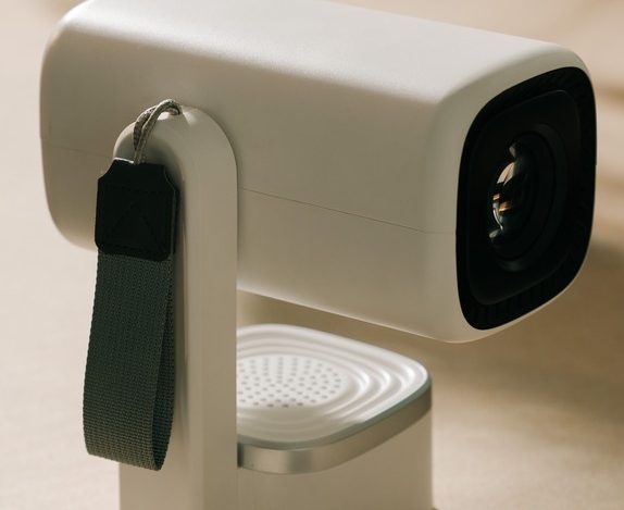 a modern white portable mini projector with a carrying strap