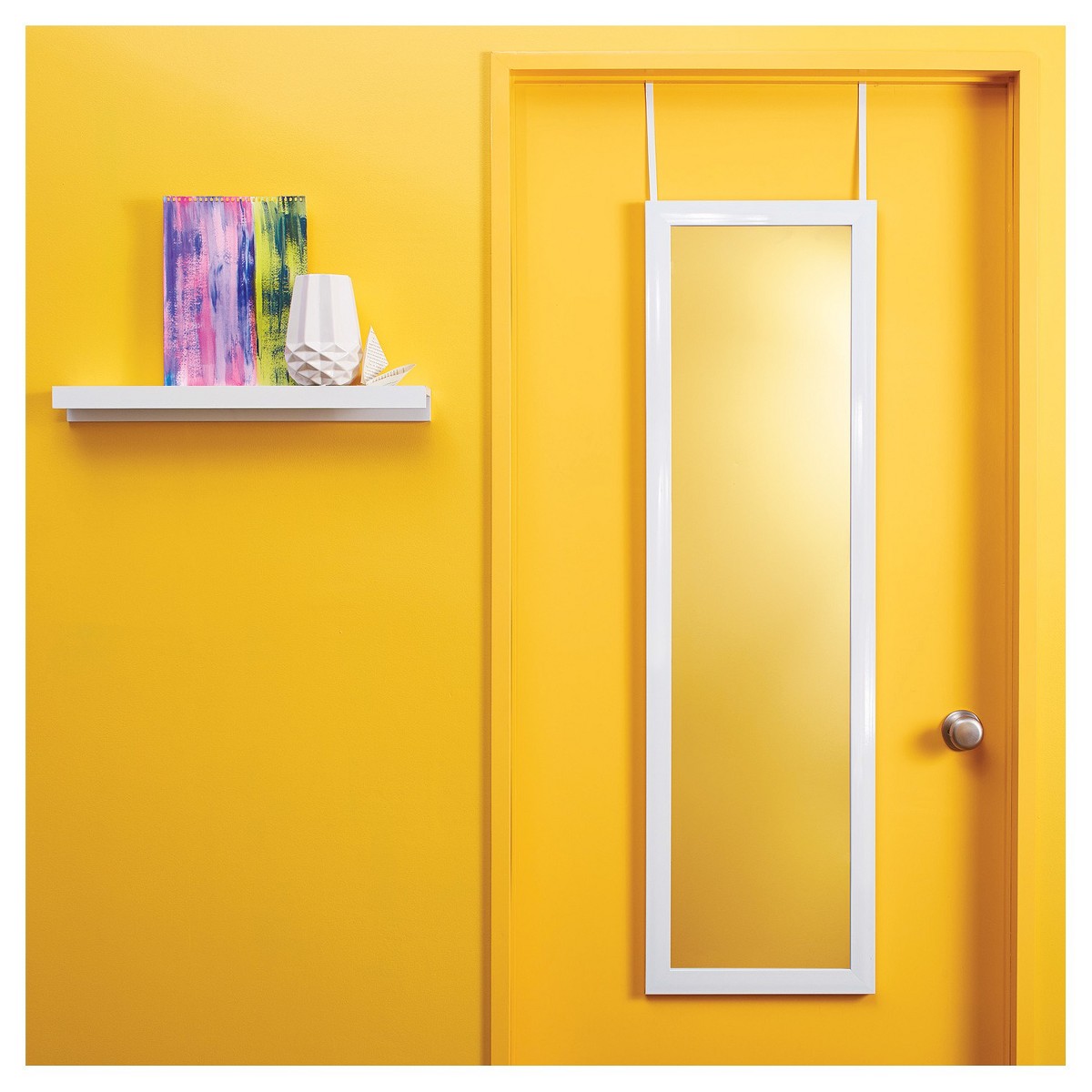 Over-the-door full length mirror hanging on a bright door