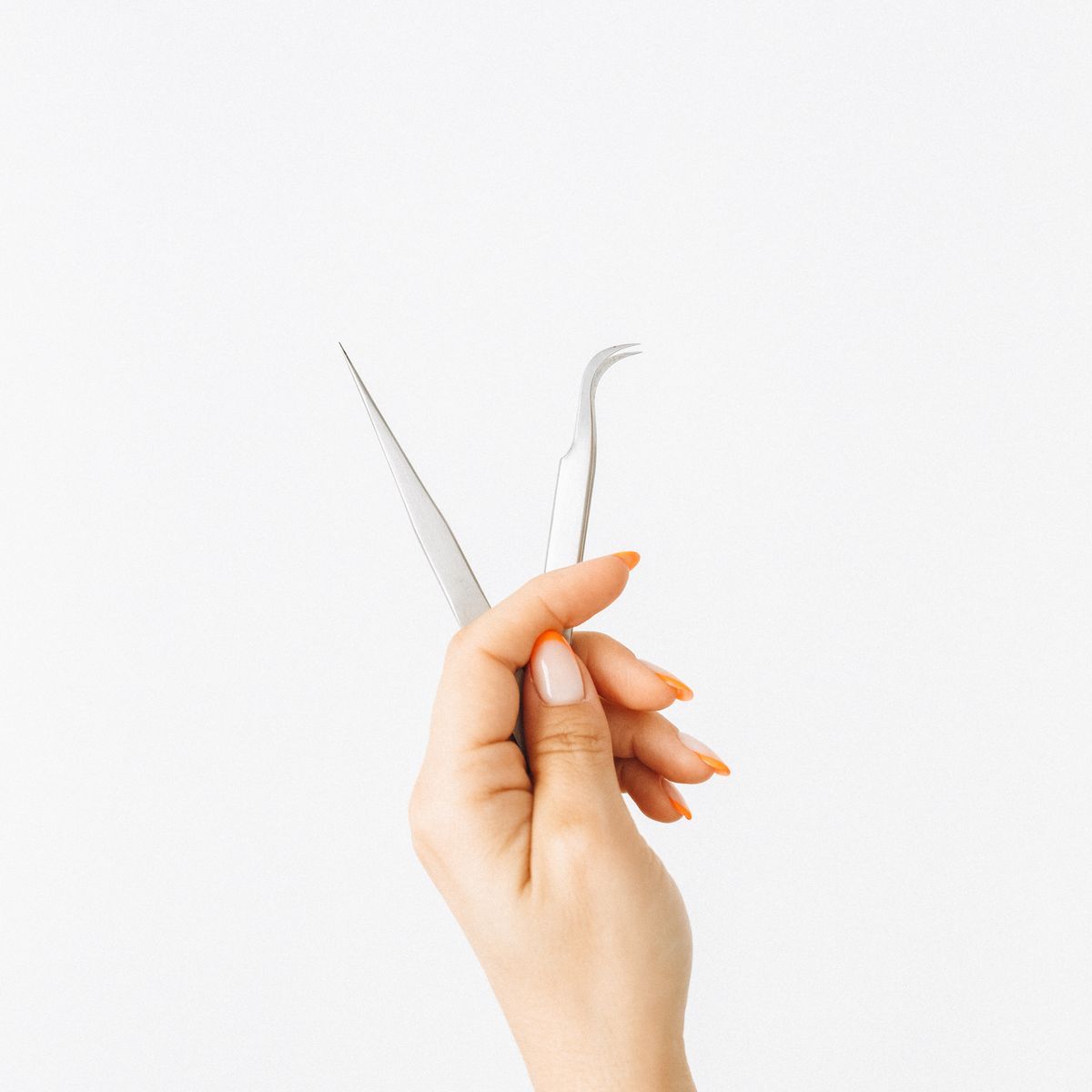 hand holding two stainless steel precision tools product photo