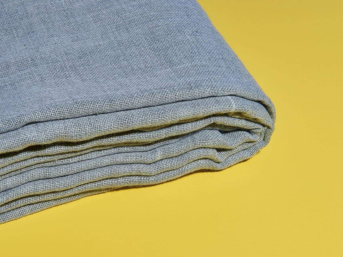 Gray primary tufting cloth folded, close-up of weave texture
