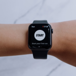 Running watch showing a run-tracking app on a wrist, marble background