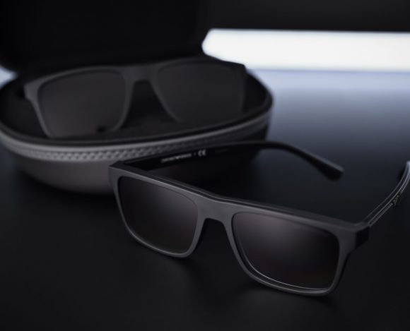 dark rectangular sunglasses resting near their case with dramatic tech lighting