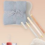 a collage of back to school teacher gifts including a blanket, pens, tumbler, and slippers
