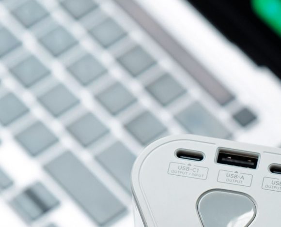 Close-up of a portable power bank with USB-C and USB-A ports near a laptop keyboard, best portable power banks