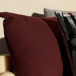 Cozy warm-lit scene with textured throw pillows and pillar candles, best self-care gifts