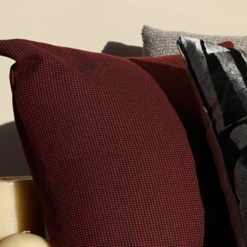 Cozy warm-lit scene with textured throw pillows and pillar candles, best self-care gifts