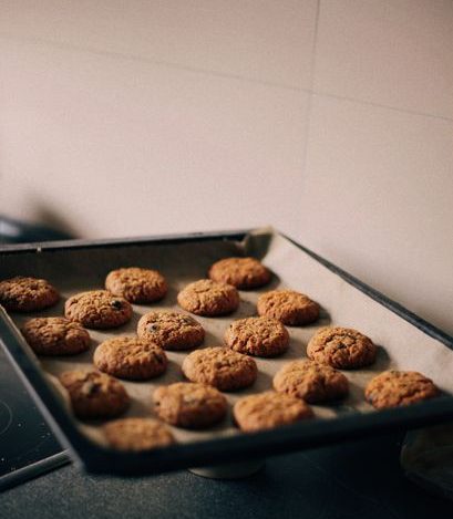 Freshly baked cookies on a baking sheet pan in a kitchen