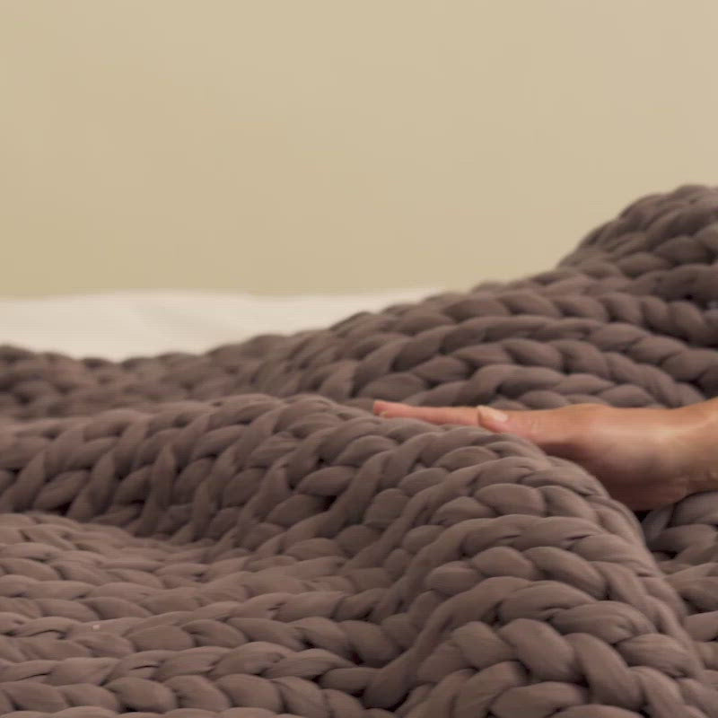 Bearaby Tree Napper chunky knit weighted blanket draped on a bed