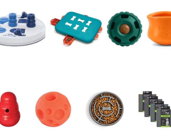A clean two-row lineup of real dog enrichment toys on white, each grounded on a shared baseline: a Nina Ottosson Dog Casino puzzle, TRIXIE Activity Flip Board, Omega Paw Tricky Treat Ball, West Paw Toppl, KONG Wobbler, a treat ball, Outward Hound Fun Feeder Slo Bowl, and a LickiMat Tuff Soother 4-pack