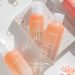 Pastel pink K-beauty flat lay with Laneige skincare bottles, rose quartz roller, and rings, k-beauty essentials