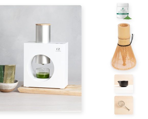 The Cuzen Matcha Maker dispensing fresh matcha into a glass on the left, with a Jade Leaf ceremonial matcha tin, a bamboo matcha whisk set, a black ceramic chawan bowl, and a stainless steel matcha sifter arranged on the right