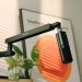 Microphone on a boom arm lit by warm sunlight on a modern streaming desk setup