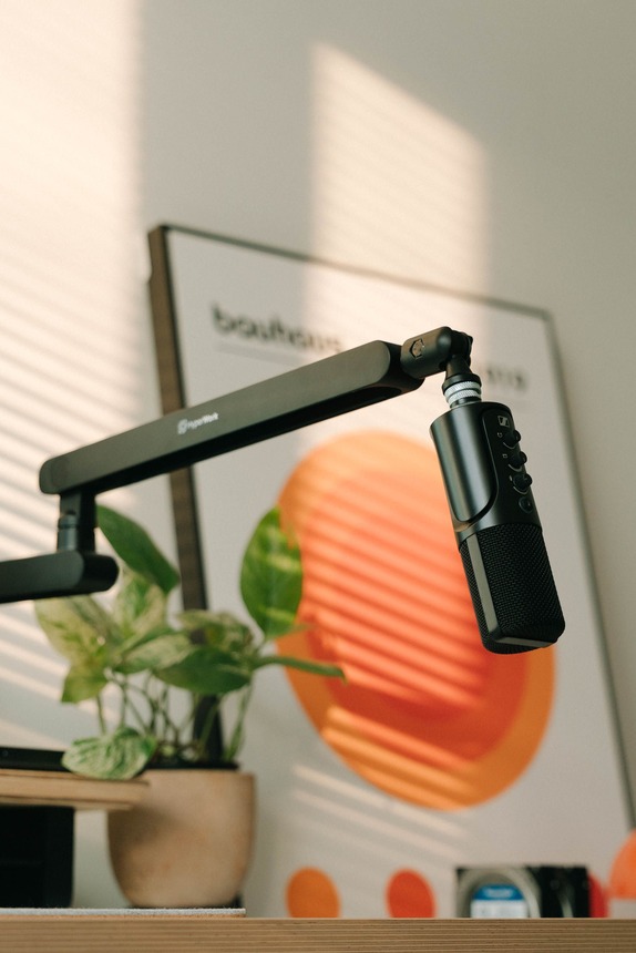 top-10-streaming-setup-essentials-hero Microphone on a boom arm lit by warm sunlight on a modern streaming desk setup